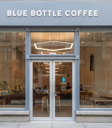 Blue Bottle Coffee New York City Blue Bottle Coffee is an upscale café that originated in Oakland, California and has expanded to New York City. Situated in various locations around the city, including the trendy neighborhood of Williamsburg in Brooklyn and the iconic Rockefeller Plaza, Blue Bottle Coffee has become a popular destination for coffee lovers. With its sleek and minimalist interior design, Blue Bottle Coffee offers customers a calming environment to enjoy their handcrafted beverages. What sets Blue Bottle Coffee apart from other chains is its commitment to providing fresh and high-quality coffee. They ensure this by sourcing their beans from reputed farmers and roasting them on-site at each café location. Customers can choose from a selection of single-origin coffees or opt for one of Blue Bottle's signature blends, such as their rich Hayes Valley Espresso. In addition to their acclaimed coffee options, Blue Bottle also offers a range of delicious pastries and snacks to complement your beverage. From flaky croissants to buttery scones, there is something to satisfy every craving. Moreover, they prioritize using local and organic ingredients whenever possible, ensuring an elevated culinary experience for their patrons. The baristas at Blue Bottle Coffee are well-trained professionals who take pride in crafting the perfect cup of coffee. They strive for consistency in every step of the brewing process, from grinding the beans to finessing latte art on top of your cappuccino. Their dedication not only ensures a fantastic cup of coffee but also contributes to the overall atmosphere of excellence within the café. Whether you are grabbing a quick weekday morning pick-me-up or looking for a cozy spot to meet with friends over some artisanal brews, Blue Bottle Coffee provides a unique experience for any occasion.